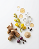 Flat lay of Juvelixir ingredients: astragalus root, yellow flowers, berries, black pepper, crystals and powder
